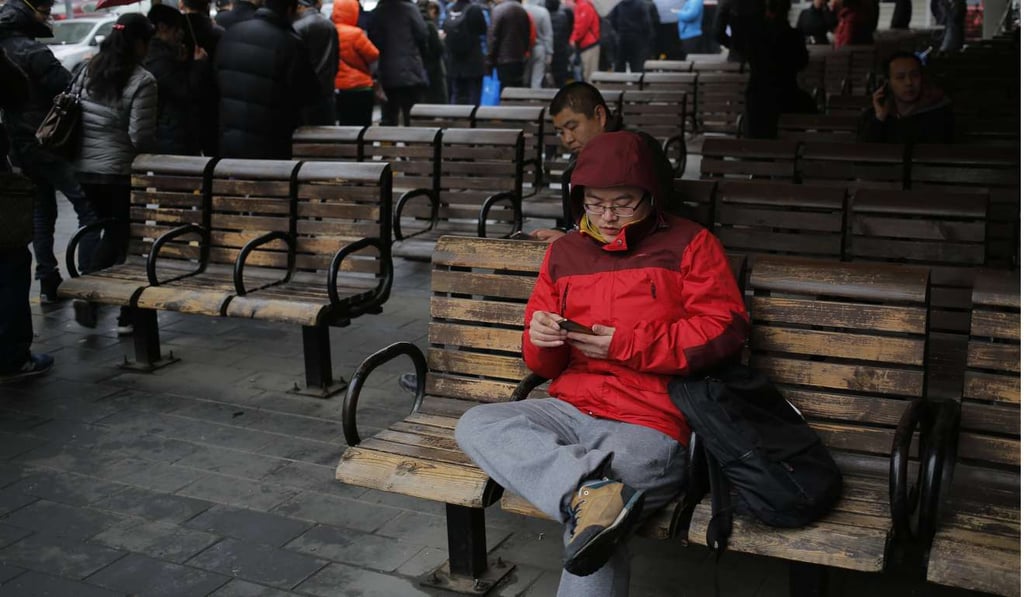 A man uses his mobile phone in Beijing. Tencent launched WeChat in 2011. Since then, this simple instant messenger mobile application has evolved into a global “super app”, with 846 million monthly active users worldwide. Photo: EPA