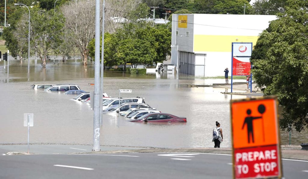 Vehicles are submerged in flood water near the train station in Beenleigh, south of Brisbane, Queensland, Australia. Photo: EPA