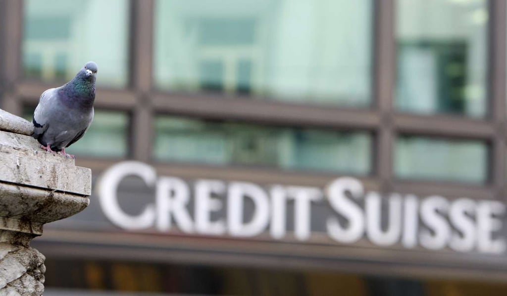 A pigeon rests near a building hosting offices of Credit Suisse bank in Milan, Italy. European authorities are investigating dozens of people suspected of tax evasion involving the Swiss bank. Photo: AP