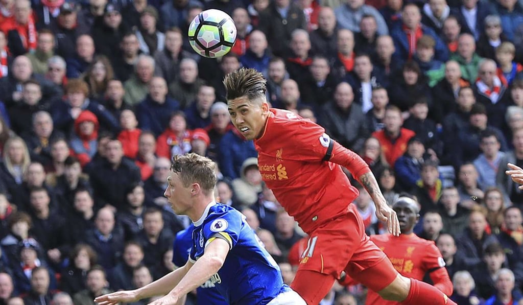 Liverpool's Roberto Firmino vies for the ball with Everton's Matthew Pennington. Photo: AP