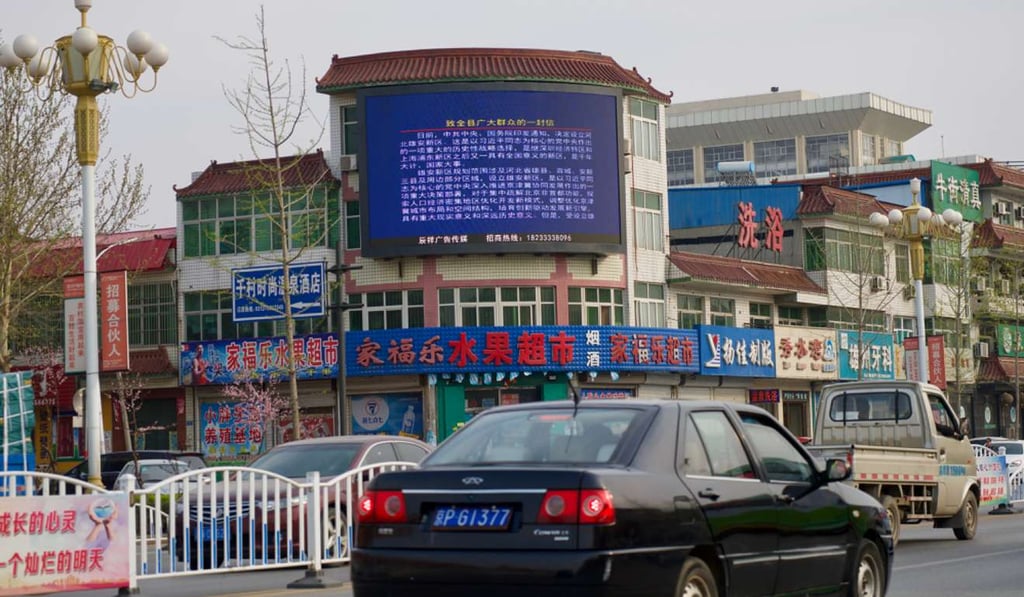 A huge screen in Xiongxian’s town centre warns against property speculation. Photo: Tom Wang