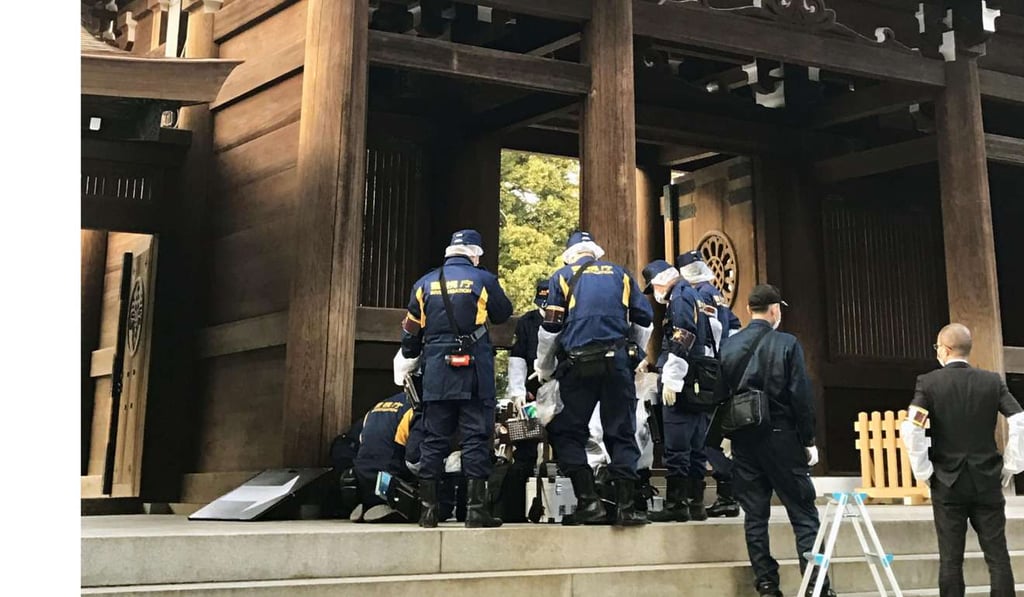 Police officers investigate Meiji Shrine, a Shinto site in Tokyo, after stains, apparently traces of a liquid, were found on its structures. Photo: Kyodo