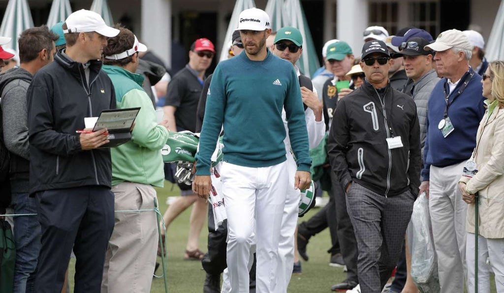 Dustin Johnson of the US arrives on the putting green before pulling out of the tournament due to injury during first round play at the 2017 Masters golf tournament. Photo: Reuters