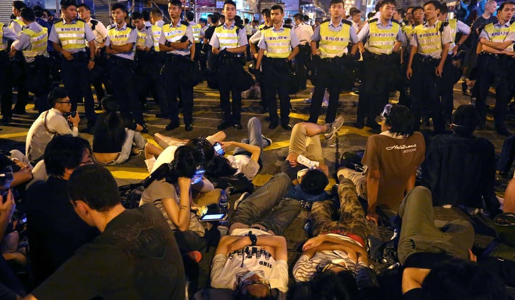 Police officers stand guard after protesters reoccupied Nathan Road in Mong Kok in October 2014, during the Occupy Central protest movement. Insultingly, the community spirit – the sense of common fate and common destiny – that Leung Chun-ying had once hoped to build did indeed occur: on the streets of Central, Causeway Bay and Mong Kok. Photo: Sam Tsang