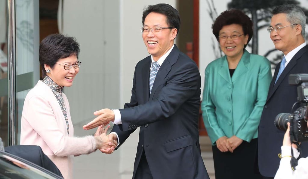 Carrie Lam shakes hands with Zhang Xiaoming, director of the liaison office, during her visit there last month. Photo: Edward Wong