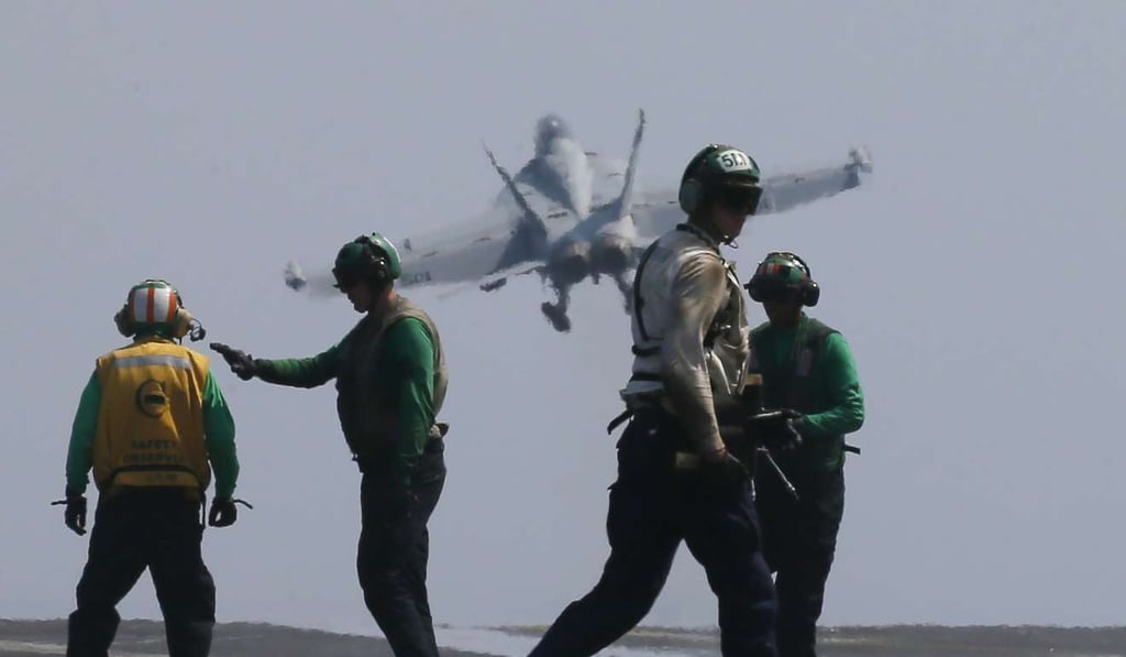 An F-18 fighter takes off from the Carl Vinson for a patrol off the disputed South China Sea on March 3. Photo: AP