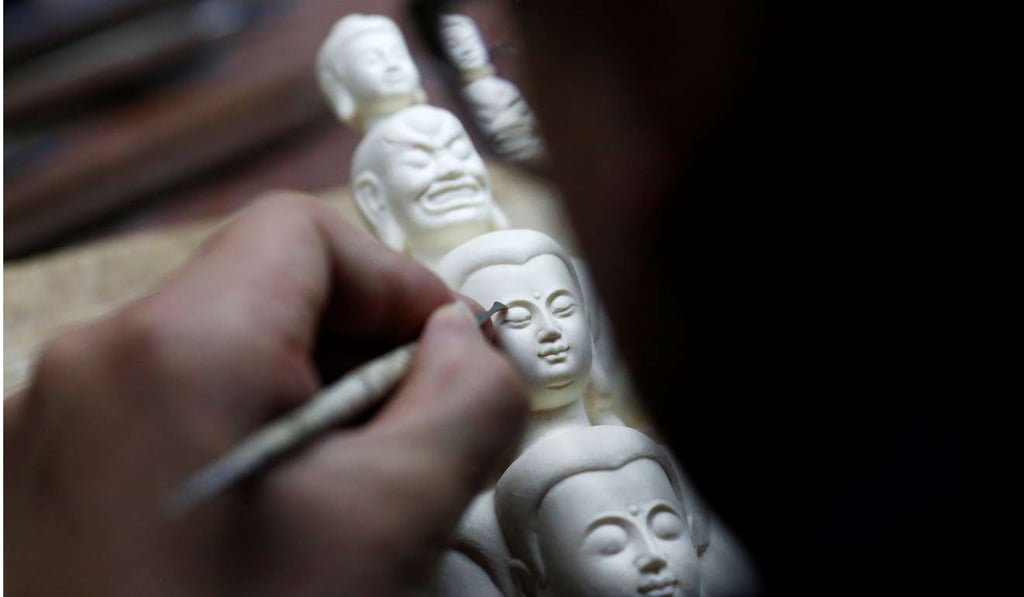 A man carves ivory at a workshop in Beijing last month. China has pledged to halt the domestic ivory trade by the end of this year. Photo: Reuters