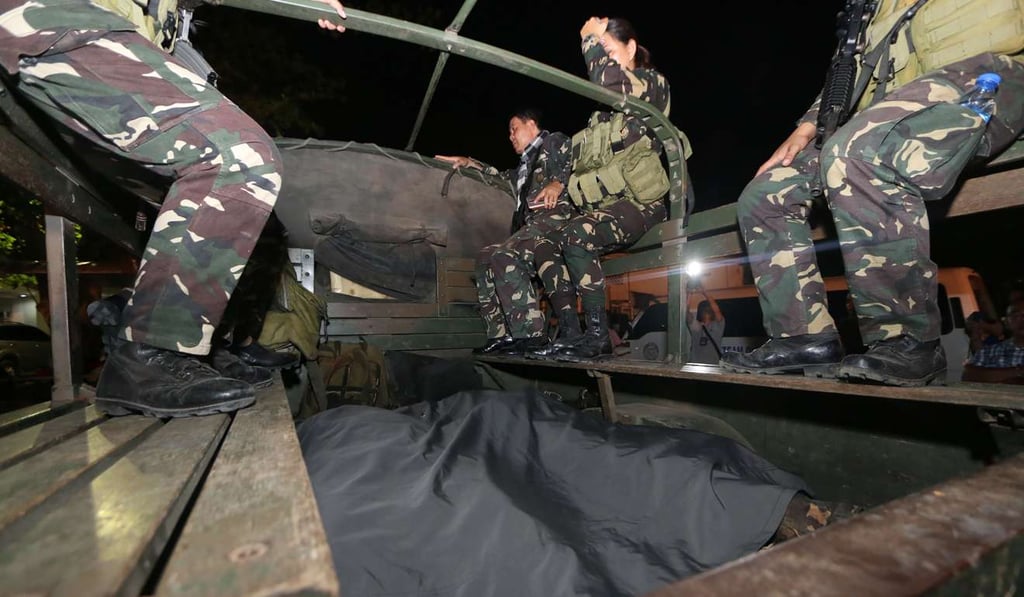 Soldiers alongside the bodies of colleagues killed in clashes in the village of Napo, Inabanga town, Bolo province. Photo: AFP