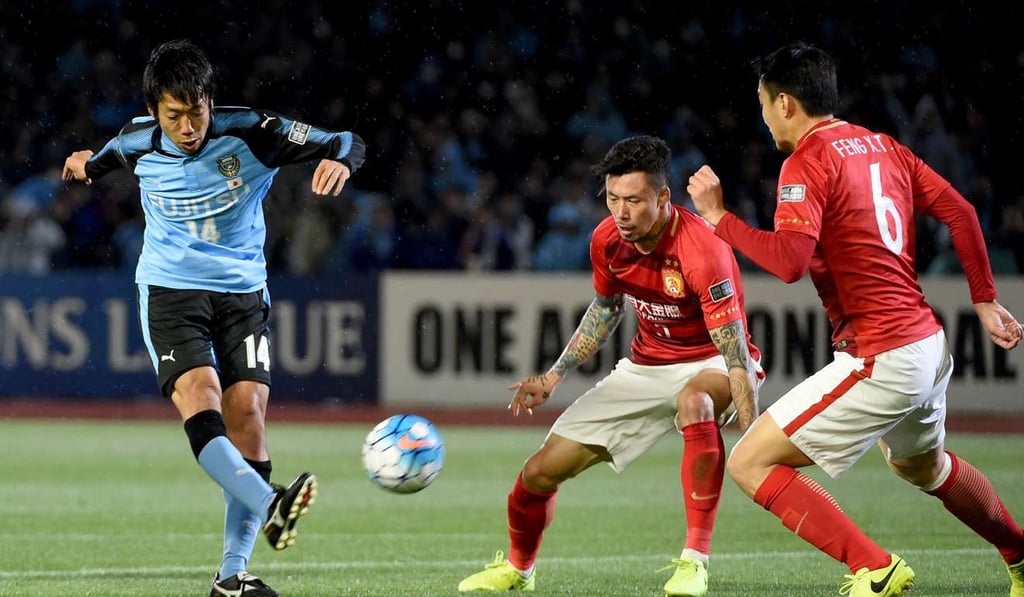 Kawasaki Frontale midfielder Kengo Nakamura (left) shoots the ball past Guangzhou Evergrande’s Zhang Linpeng (centre) and Feng Xiaoting. Photo: AFP