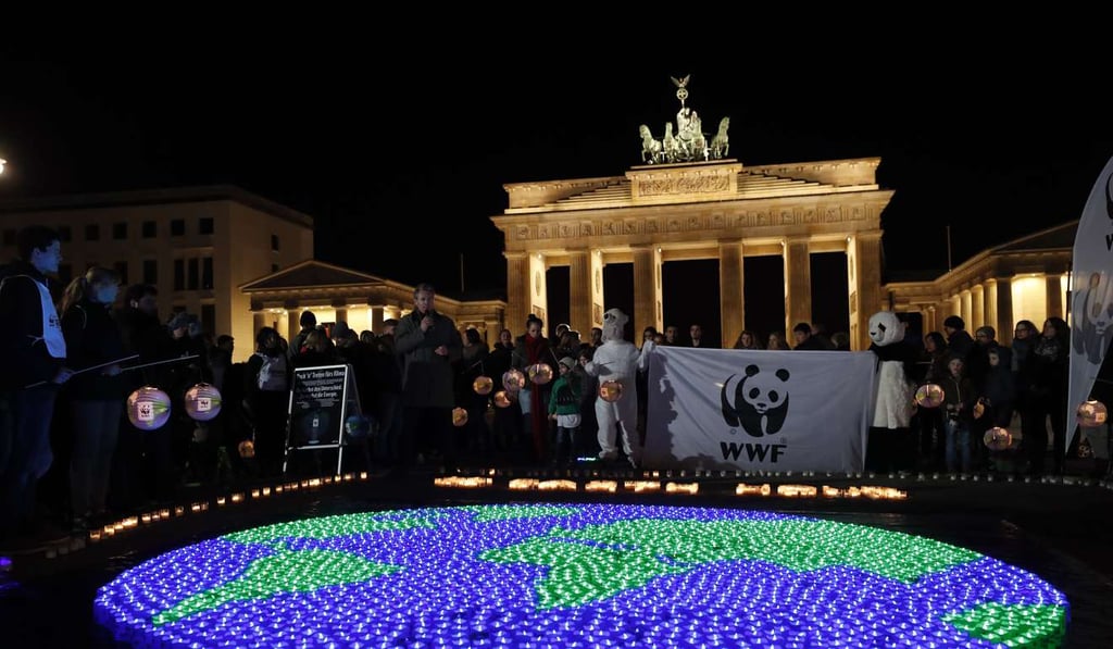 Candles are lit in front of the Brandenburg Gate before turning off its lights to commemorate Earth Hour in Berlin, Germany. Photo: EPA