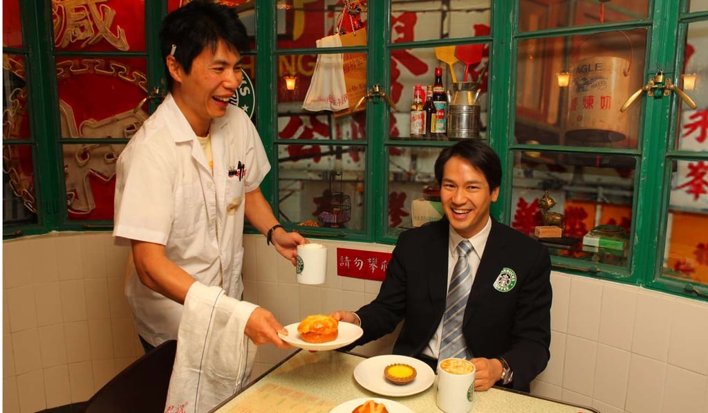 Dressed like an old-time bing sutt waiter, Douglas Young of lifestyle store G.O.D. serves a caramel macchiato, coffee egg tart and coffee cocktail bun to Maxim's’ Michael Wu at the opening of Starbucks’ bing sutt corner in Duddell Street, Central, in 2009.