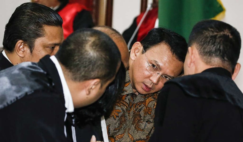 Jakarta Governor Basuki Tjahaja Purnama, centre, talks to his lawyers inside the courtroom during his blasphemy trial at the North Jakarta District Court in Jakarta, Indonesia. Photo: EPA