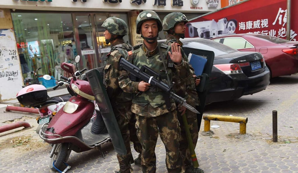In this file photo from April 2015, paramilitary police officers guard a shopping mall in Hotan. Photo: AFP
