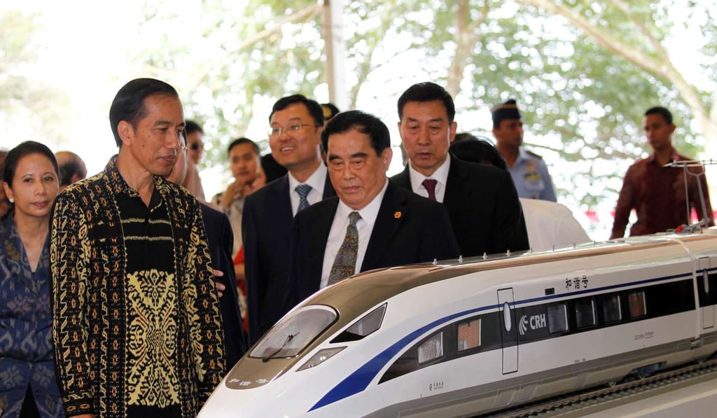 Indonesian President Joko Widodo, second from left, and the general manager of China Railway Sheng Guangzu, centre, stand next to a train model as they attend a groundbreaking ceremony for the Jakarta-Bandung fast-train railway line in Walini, West Java province, Indonesia. Photo: Reuters