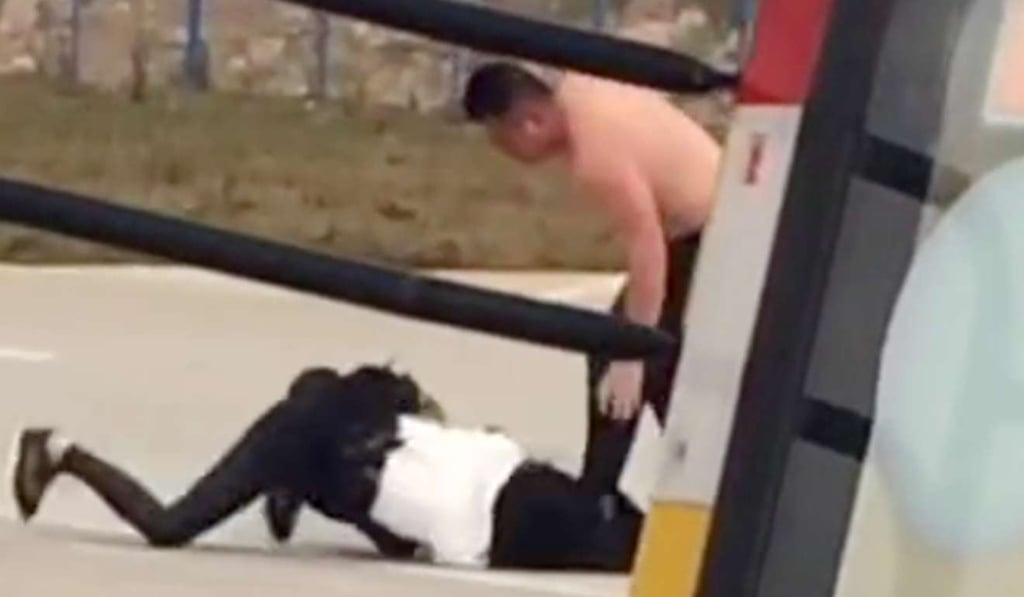 The husband, shown without his shirt, fighting with his wife on the tarmac. The couple late tried to enfer the aircraft but were barred by the pilot. Photo: Handout
