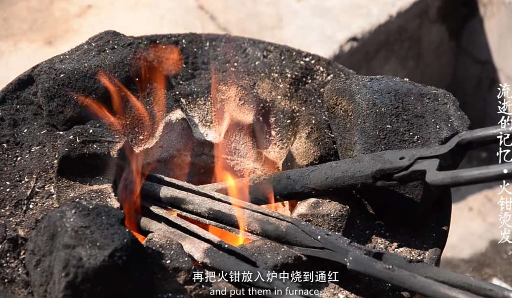 The tongs are plunged into the heat before a perm. Photo: Sina.com.cn The tongs are plunged into the heat before a perm. Photo: Sina.com.cn
