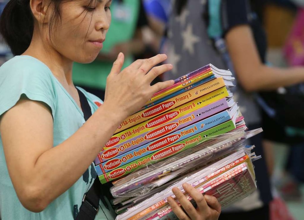 A customer buys assessment papers on the first day of the Hong Kong Book Fair last year. It did not take publishers long to see that there was a market in producing mock TSA exam papers. Photo: K. Y. Cheng