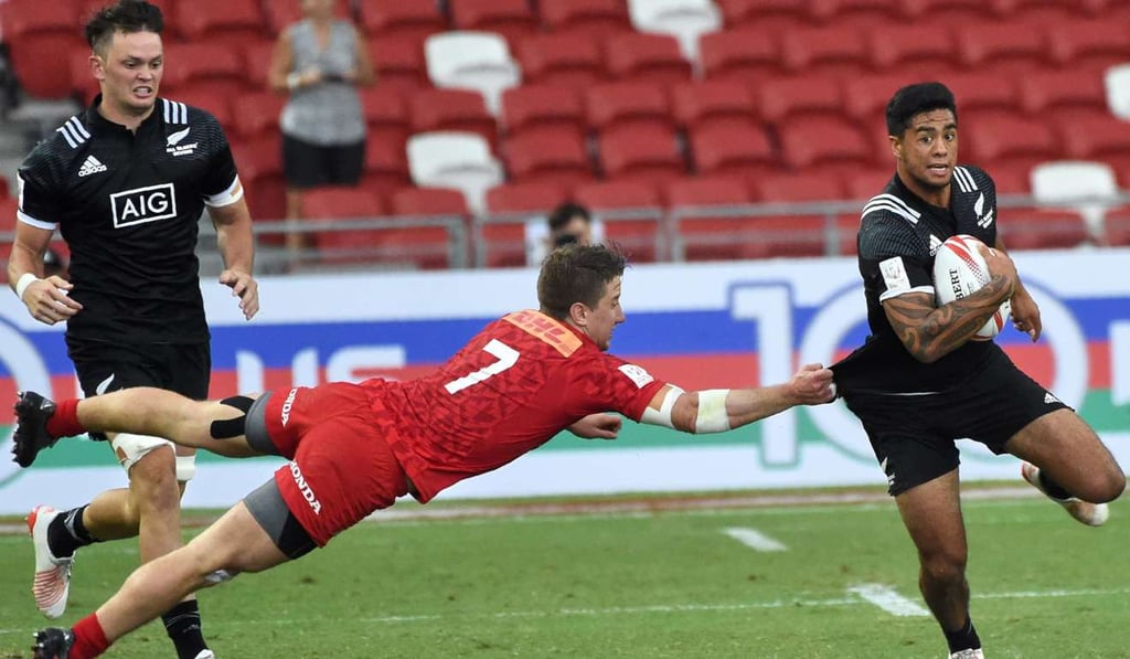 Lucas Hammond of Canada attempts a tackle on Regan Ware of New Zealand during the quarter-final of the Singapore Sevens, Photo: AFP