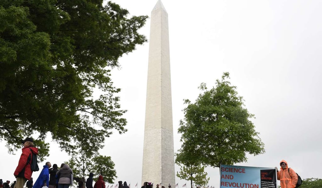 A man stand by a sign that reads