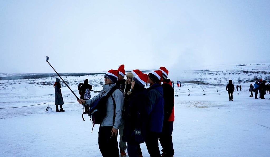 Tourists wearing Santa hats take a selfie as geysers discharge water at Geysir, in Iceland. In an increasingly globalised world, there are fears the Icelandic language may not survive. Photo: Reuters