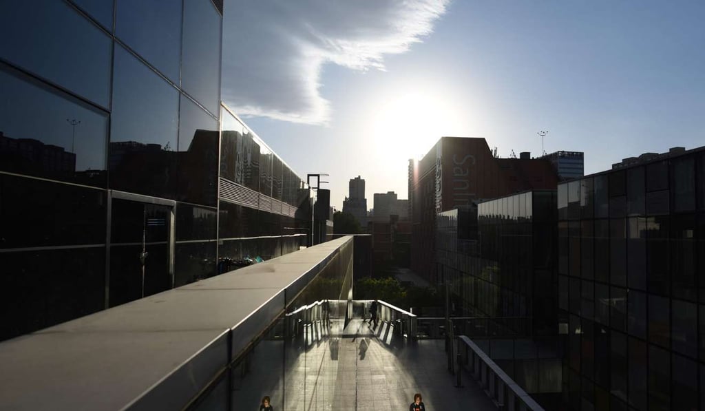 The International Monetary Fund on April 18 raised its economic growth forecast for China for this year and next but warned of serious longer-term problems unless it reduces its reliance on credit. A woman walks past shops in a mall in Beijing. Photo: AFP