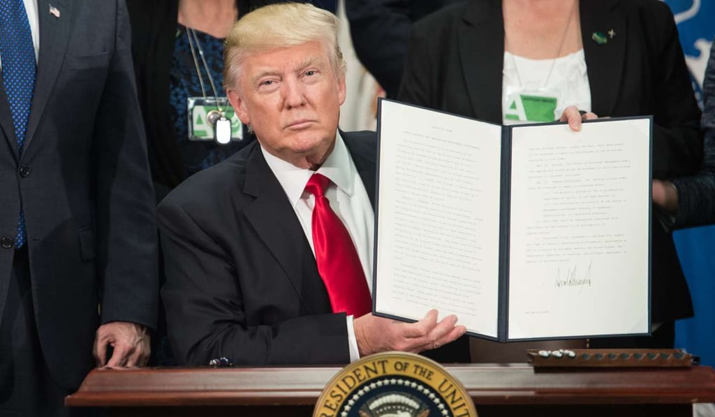 US President Donald Trump signs an executive order to start the Mexico border wall project at the Department of Homeland Security facility in Washington on January 25. Photo: AFP
