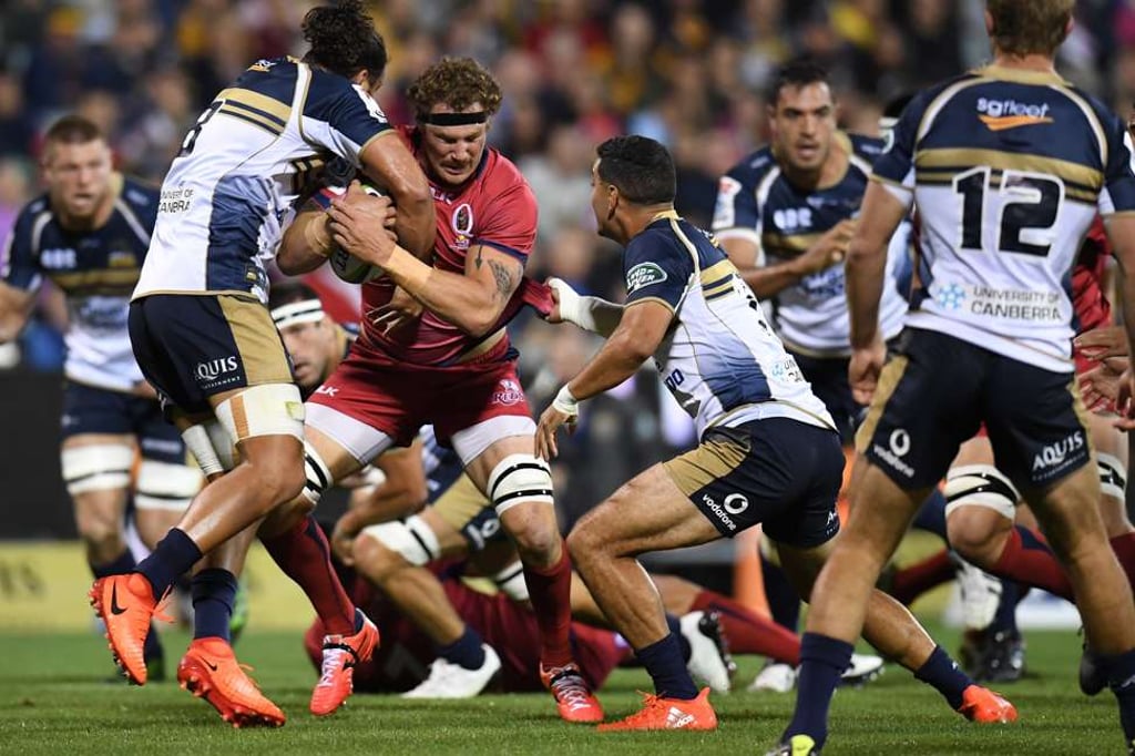 Jordan Smiler of the Brumbies tackles Scott Higginbotham of the Reds. Jordan Smiler of the Brumbies tackles Scott Higginbotham of the Reds.