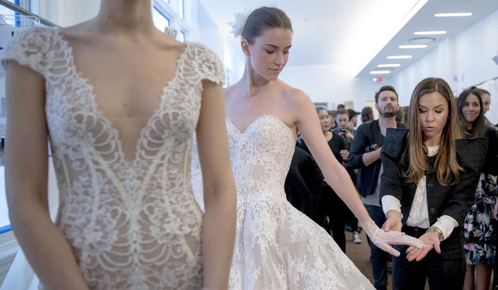 Monique Lhuillier, right, speaks to a reporter ahead of her collection presentation during Bridal Fashion Week in New York. Photo: AP Monique Lhuillier, right, speaks to a reporter ahead of her collection presentation during Bridal Fashion Week in New York. Photo: AP