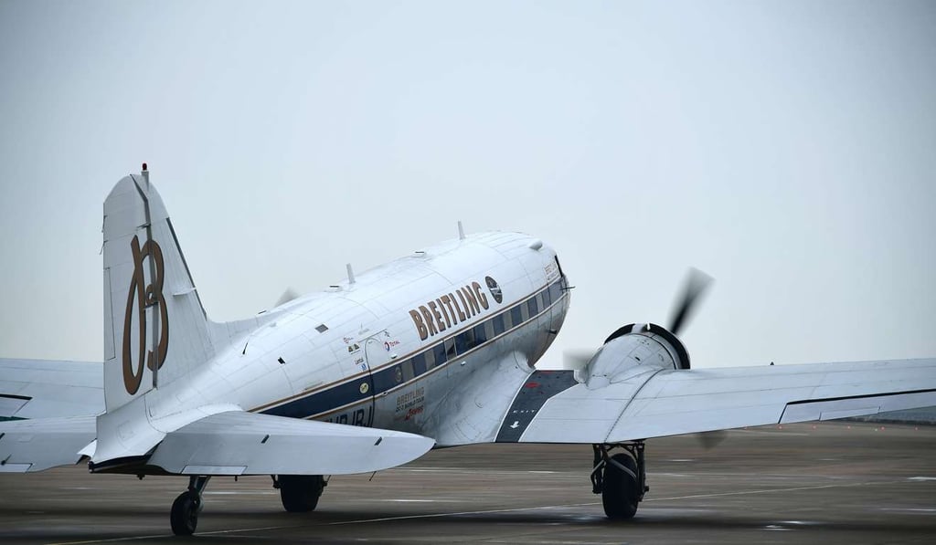 Twin-engine propeller-driven Breitling DC-3 takes off at Macau International Airport.
