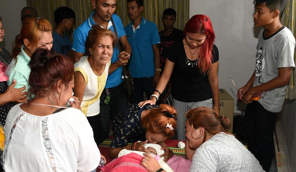 Jiranuch Trirat kisses the body of her 11-month-old daughter, who was killed by her father who broadcast the murder on Facebook. Photo: Reuters