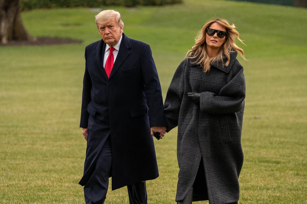 US President Donald Trump and First Lady Melania Trump walk on the South Lawn of the White House after arriving on Marine One in Washington, on December 31, 2020. Photo: Polaris/Bloomberg