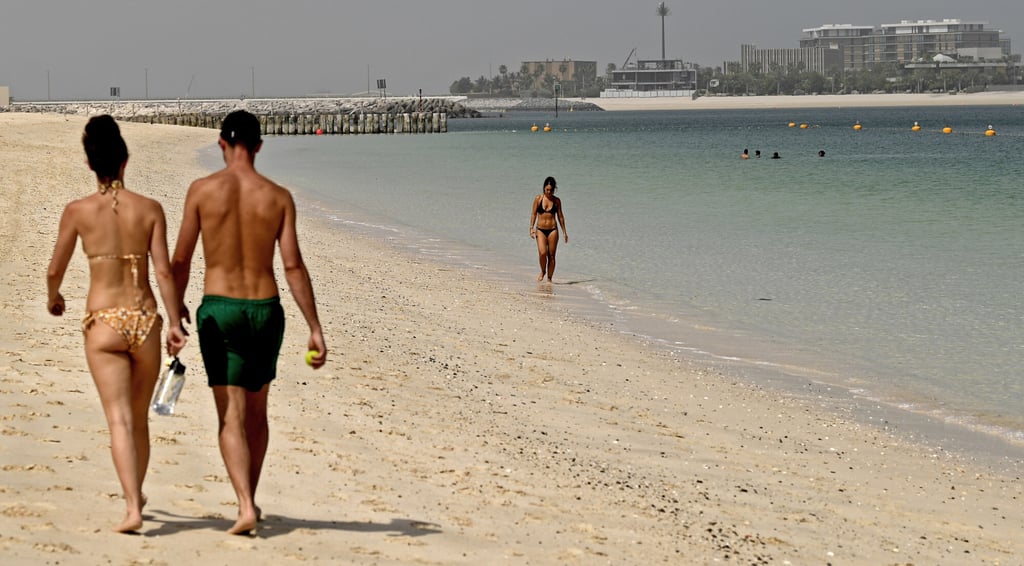 Tourists walk on the beach at the Mandarin Oriental Jumeira in July, 2020, in the Gulf emirate of Dubai. Photo: AFP Tourists walk on the beach at the Mandarin Oriental Jumeira in July, 2020, in the Gulf emirate of Dubai. Photo: AFP
