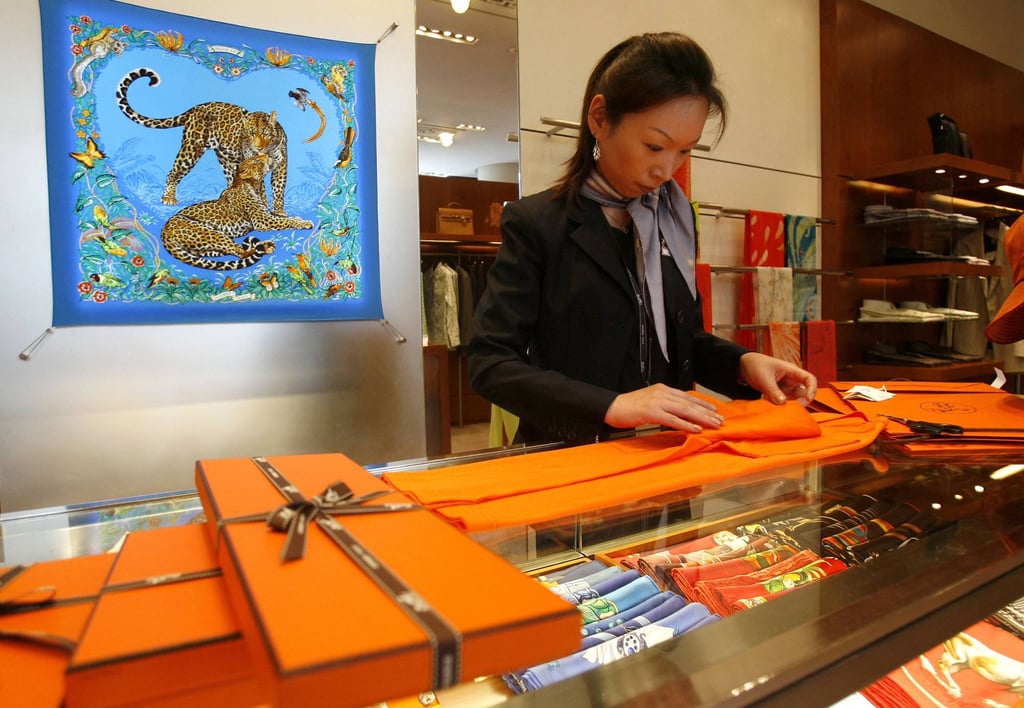 A sales assistant packs products at an outlet of French luxury brand Hermès in Shanghai. Photo: AFP A sales assistant packs products at an outlet of French luxury brand Hermès in Shanghai. Photo: AFP