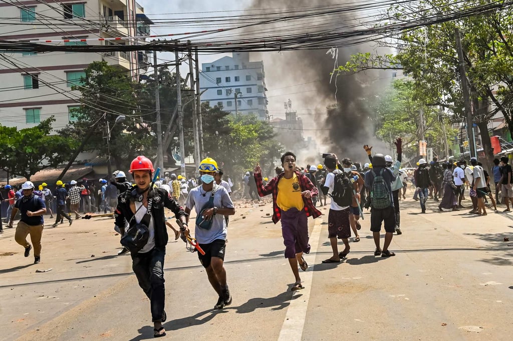 Protesters run as tear gas is fired during a crackdown by security forces on a demonstration against the military coup in Yangon on March 19. Photo: AFP Protesters run as tear gas is fired during a crackdown by security forces on a demonstration against the military coup in Yangon on March 19. Photo: AFP