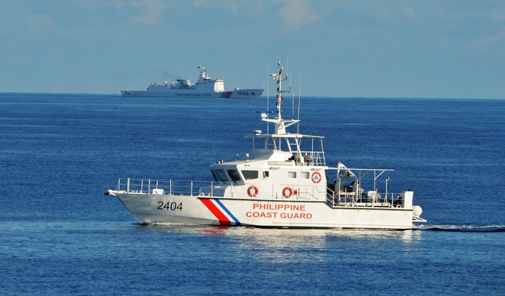 A Philippine coastguard ship sails past a Chinese coastguard ship in the South China Sea. Photo: AFP