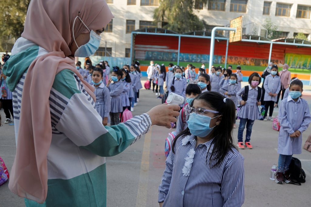 Elia Ali, a third grade Palestinian student, has her temperature taken at her school as schools gradually reopen amid the coronavirus outbreak, in Tubas in the Israeli-occupied West Bank in September. Photo: Reuters