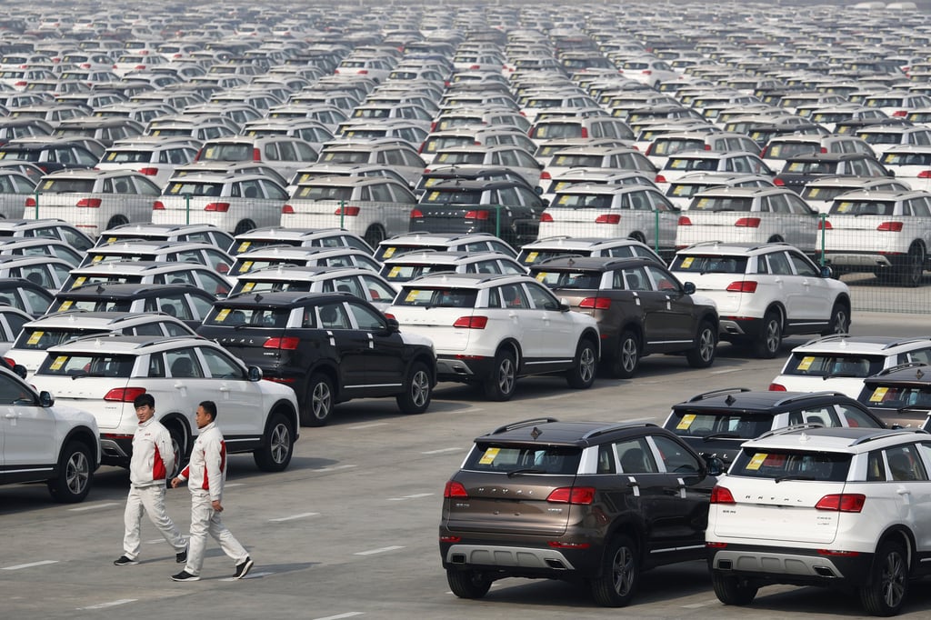Workers walk past SUVs parked outside the Great Wall Motors assembly plant in Baoding in north China’s Hebei province on March 1, 2017. Photo: AP Photo