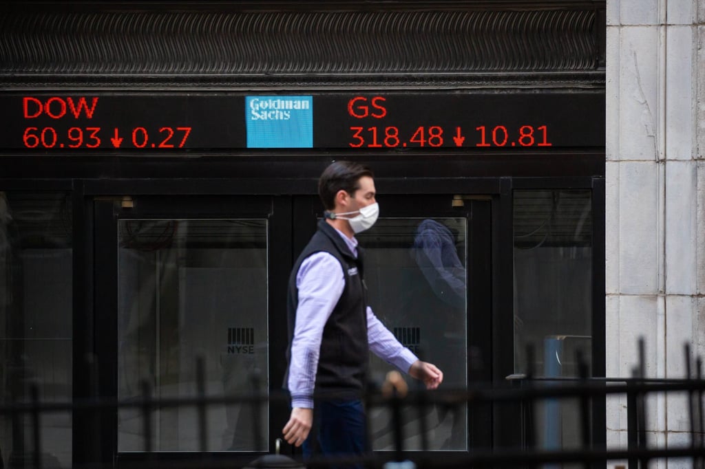 A trader passes in front of Goldman Sachs signage near the New York Stock Exchange in March 2021. Photo: Bloomberg