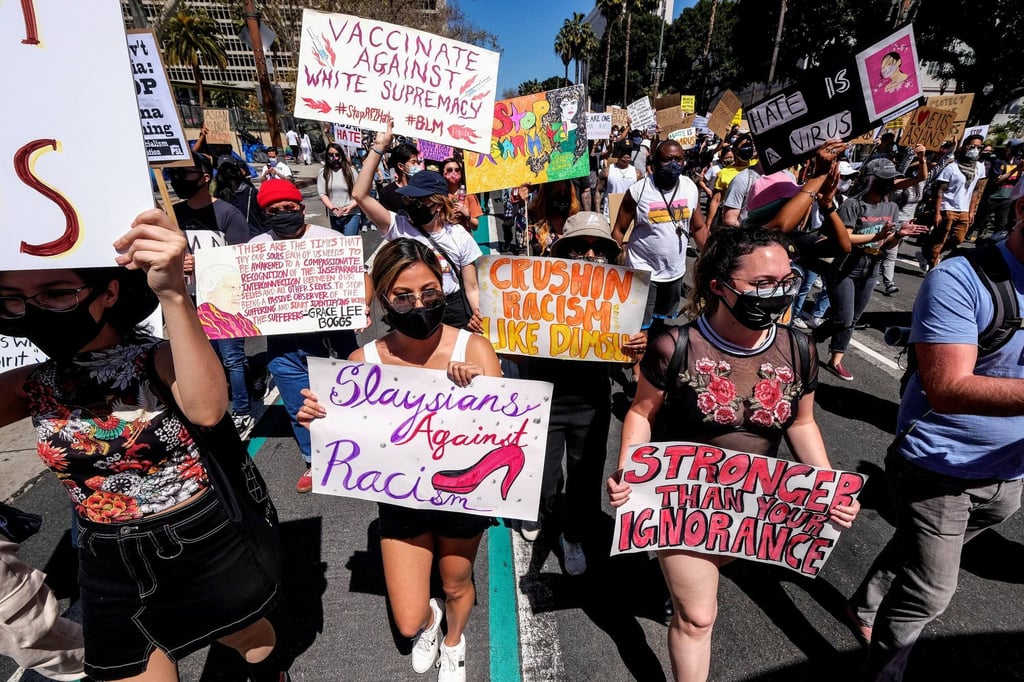 Demonstrators holding signs march during a rally against anti-Asian hate crimes outside City Hall in Los Angeles, California, on Saturday. Photo: Reuters