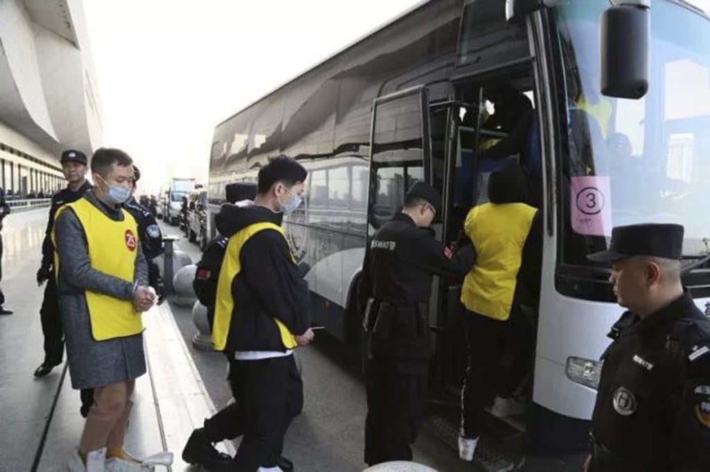 Police escort suspects of a multi-billion dollar illegal lending scheme into buses. 253 people were arrested during a dragnet in March 2019. Photo: Baidu