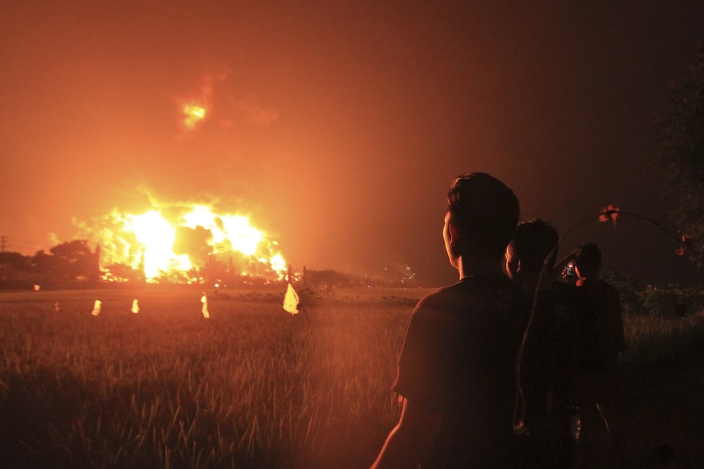 Residents look at the burning oil refinery in Indonesia. Photo: EPA-EFE