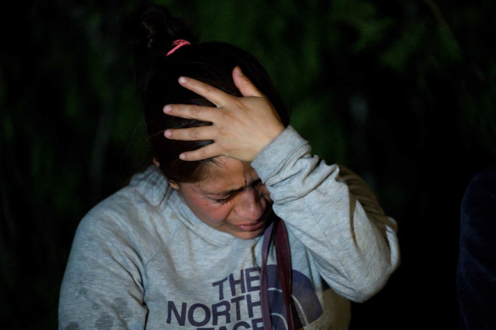 An immigrant from Guatemala, who arrived illegally across the Rio Grande river from Mexico, rests on the US side of the river bank on Saturday. Photo: AFP
