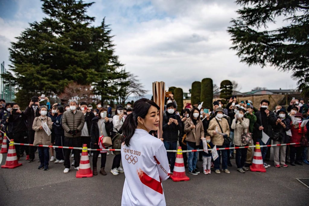 Japanese actress Momoko Kikuchi holds the Olympic torch during the second day of the Tokyo 2020 Olympic Games torch relay outside Shinobugaoka Stadium in Fukushima in March. Photo: AFP