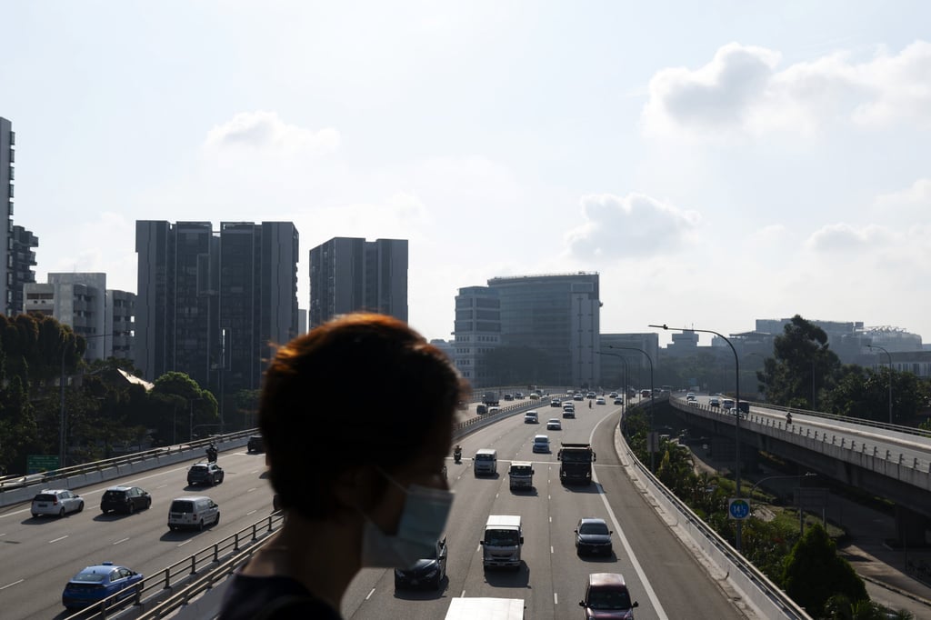 A woman walks across a bridge above vehicles travelling along the Pan Island Expressway highway during peak hours in Singapore on March 2. The government pledged last month to spend S$30 million (US$22 million) over five years for electric vehicle-related initiatives. Photo: Bloomberg A woman walks across a bridge above vehicles travelling along the Pan Island Expressway highway during peak hours in Singapore on March 2. The government pledged last month to spend S$30 million (US$22 million) over five years for electric vehicle-related initiatives. Photo: Bloomberg