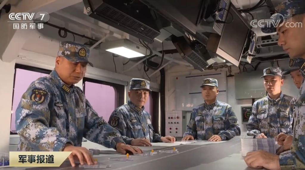 Lai Yijun, captain of the Shandong (left), and political commissar Song Wenjun (second left) play “carrier chess” using models of J-15 fighters. Photo: CCTV Lai Yijun, captain of the Shandong (left), and political commissar Song Wenjun (second left) play “carrier chess” using models of J-15 fighters. Photo: CCTV