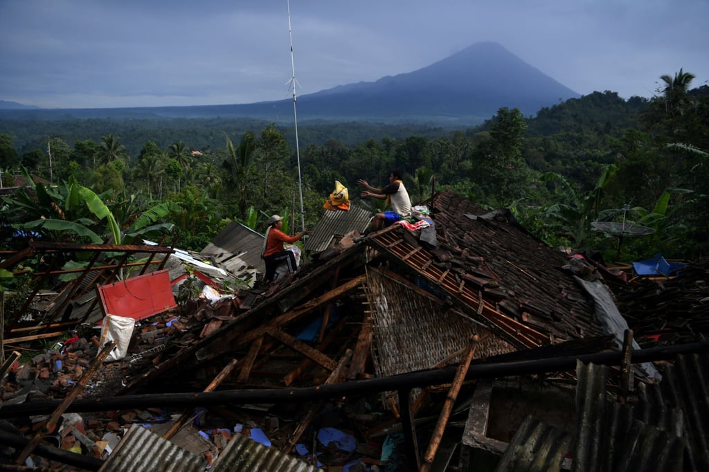 People salvage their belongings from a house damaged by an earthquake in Lumajang, East Java province. Photo: Reuters People salvage their belongings from a house damaged by an earthquake in Lumajang, East Java province. Photo: Reuters