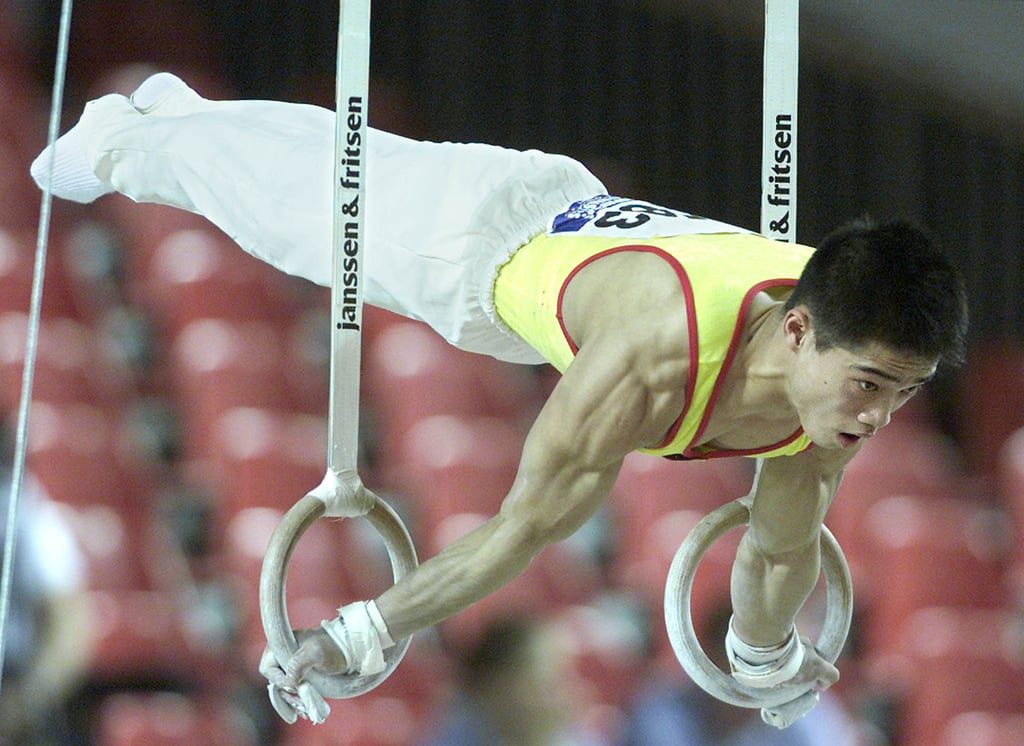 Zhang Shangwu performs on the rings at the World Artistic Gymnastic Championships in Ghent in 2001. A tendon injury brought his promising career to an end the following year. Photo: Reuters Zhang Shangwu performs on the rings at the World Artistic Gymnastic Championships in Ghent in 2001. A tendon injury brought his promising career to an end the following year. Photo: Reuters
