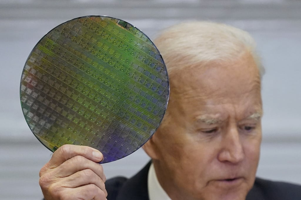 President Joe Biden holds up a silicon wafer as he participates virtually in the CEO Summit on Semiconductor and Supply Chain Resilience in the Roosevelt Room of the White House. Photo: AP