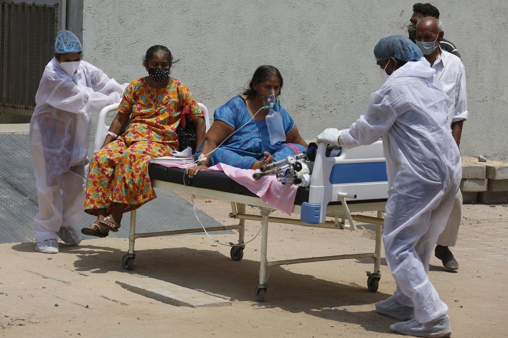 Health workers shift patients from a dedicated Covid-19 hospital to another hospital, to make space for new patients in Ahmedabad, India, on April 13. Photo: AP Health workers shift patients from a dedicated Covid-19 hospital to another hospital, to make space for new patients in Ahmedabad, India, on April 13. Photo: AP