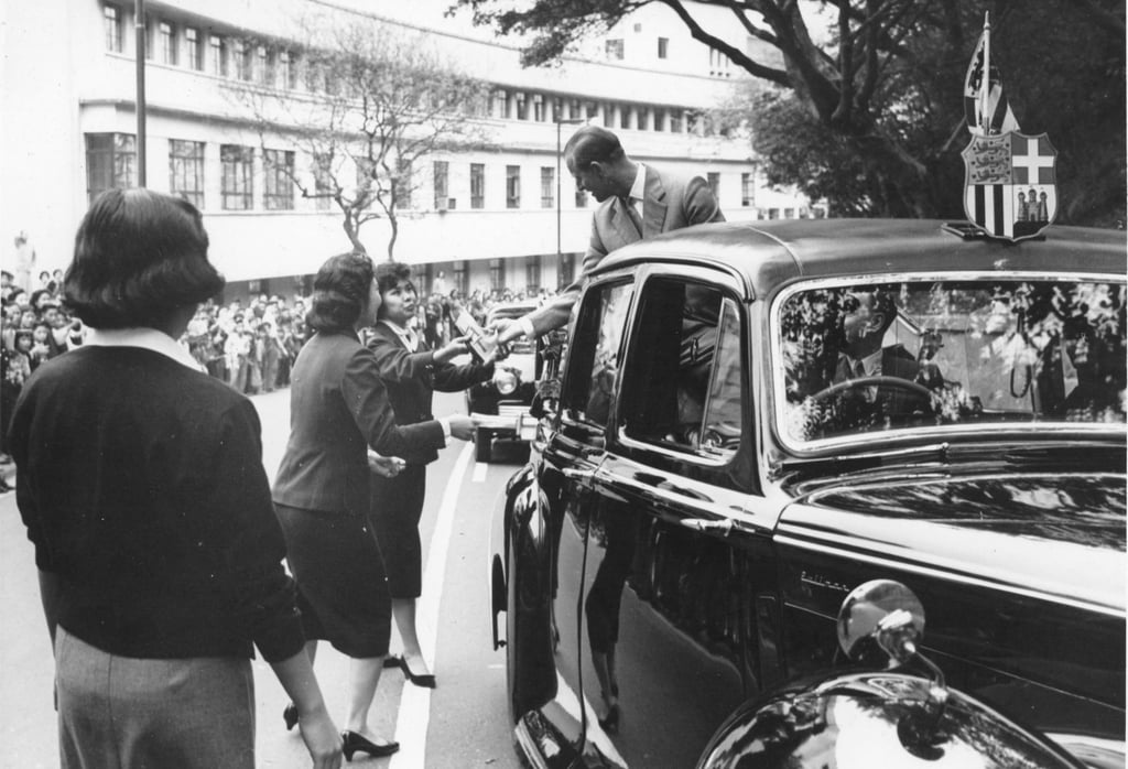 Undergraduates of the University of Hong Kong stop the car carrying Prince Philip during his drive around the island and present him with their hostel pennant in March 1959. Photo: SCMP Undergraduates of the University of Hong Kong stop the car carrying Prince Philip during his drive around the island and present him with their hostel pennant in March 1959. Photo: SCMP